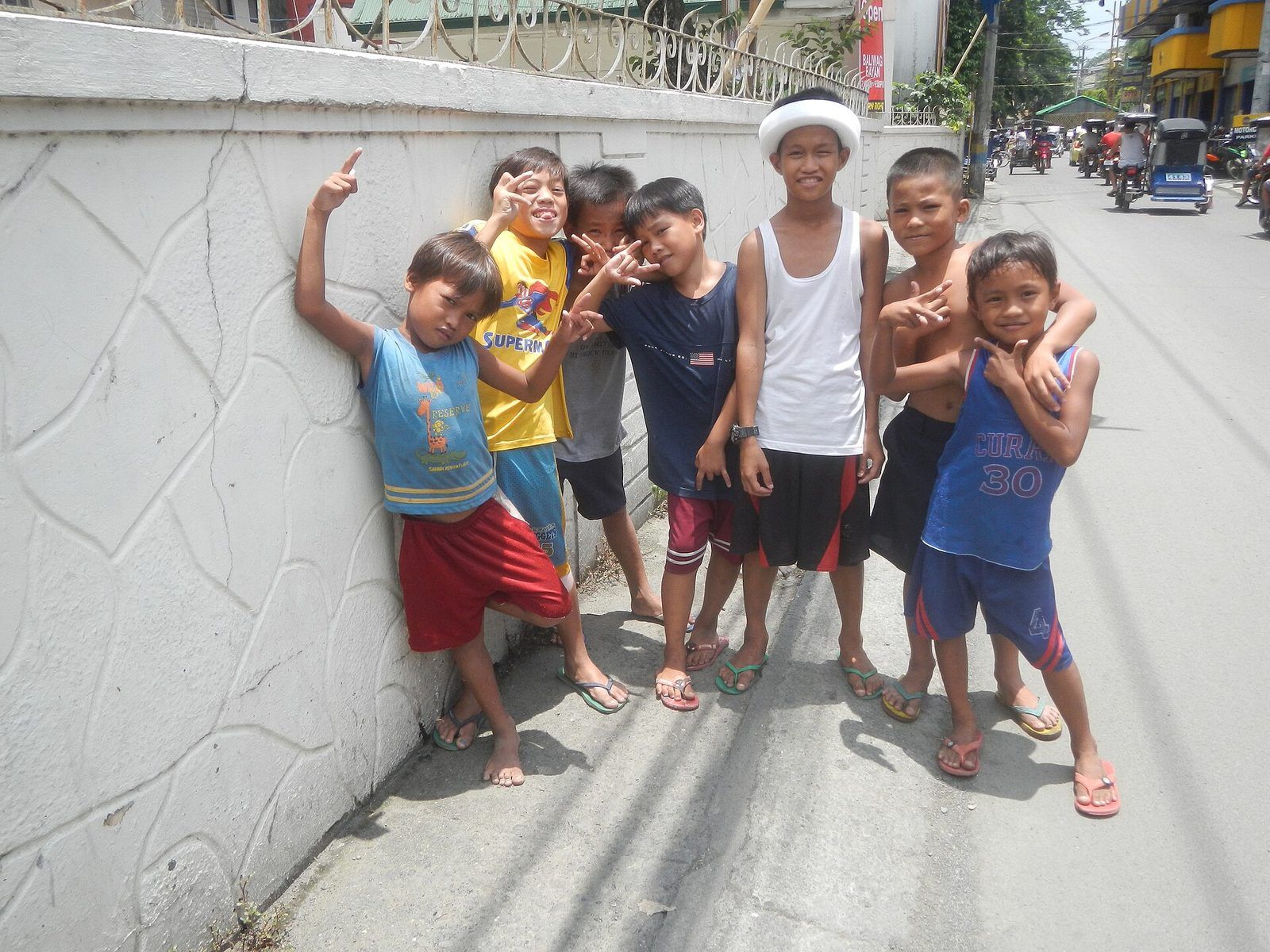 Children playing beside a wall in the Philippines